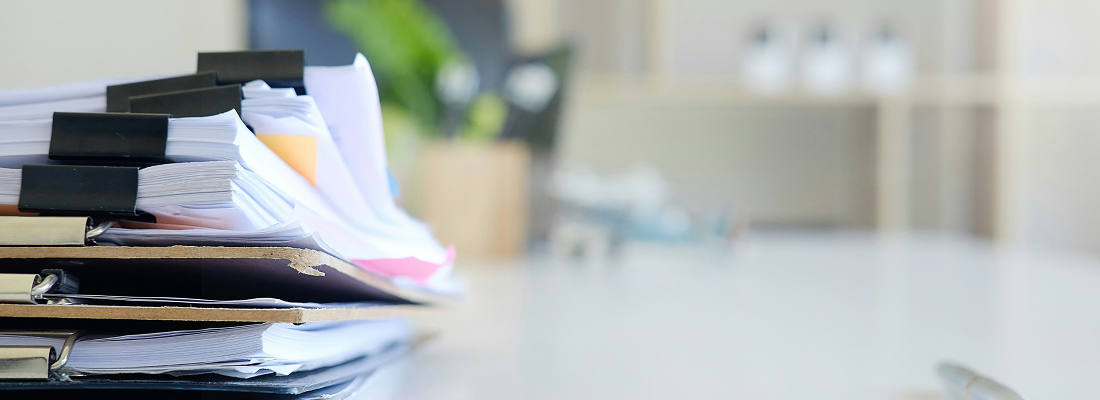 a pile of papers and documents on a desk representing this signum blog post about CPT, APC and ICD-10 Codes for Transsphincteric Anal Fistula